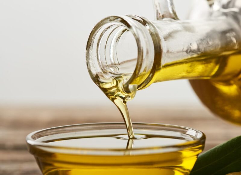 sipanje maslinovog ulja u staklenu činijicu iz staklene bočice
